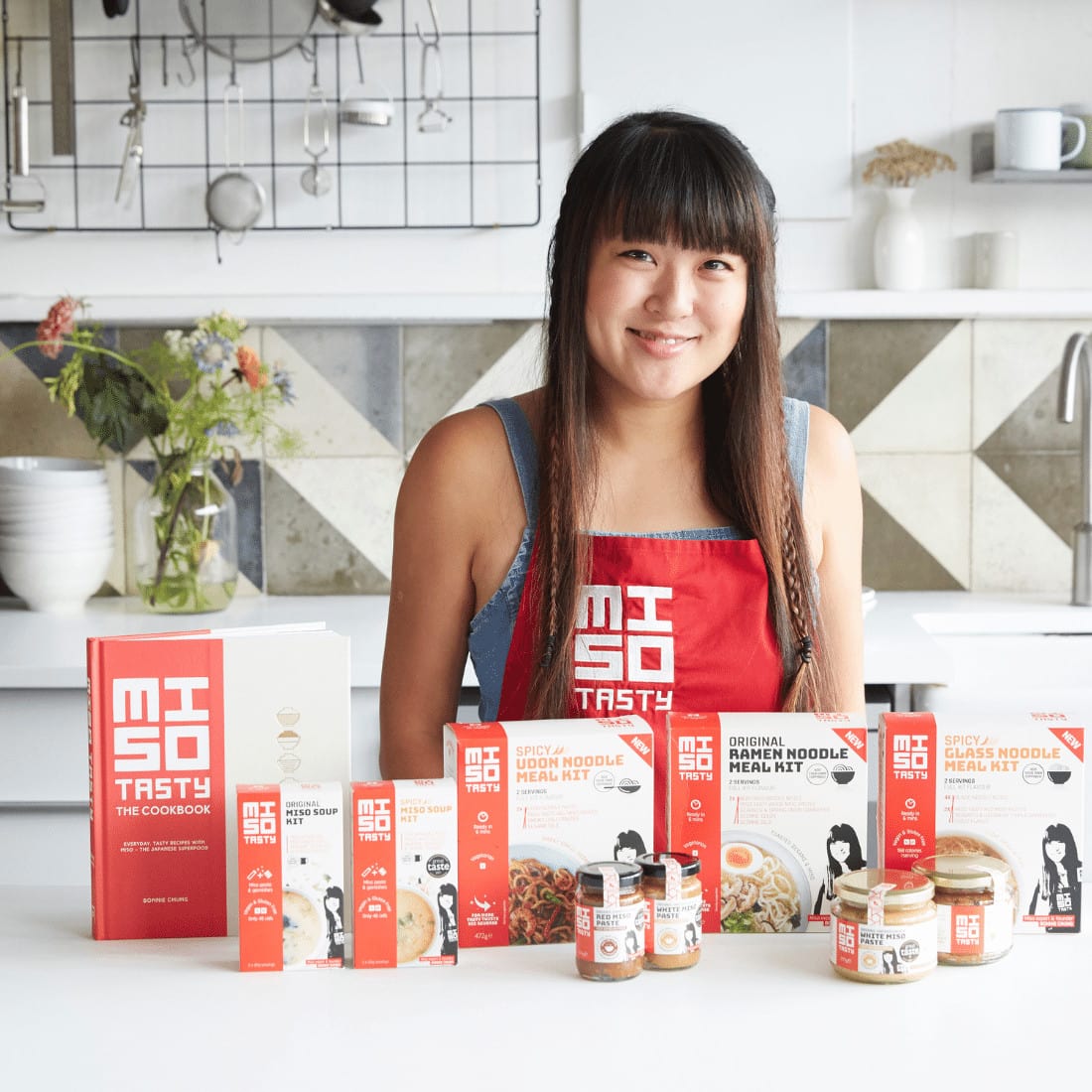 Bonnie Chung, founder of Miso Tasty, in her kitchen with her range of products on the counter in front of her
